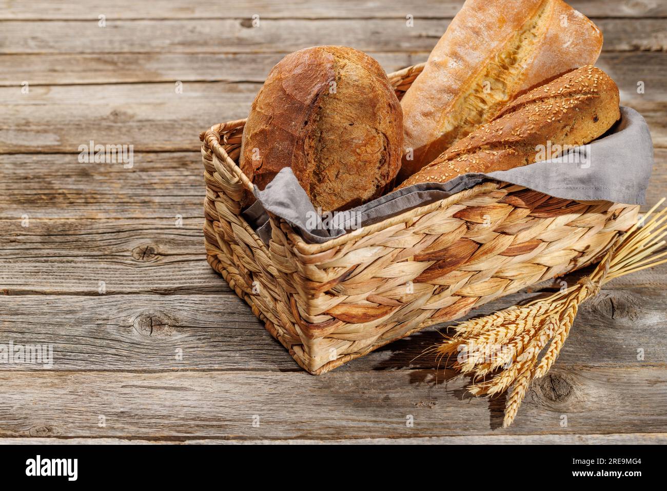 Assorted bread varieties in a charming basket, ready to be enjoyed Stock Photo