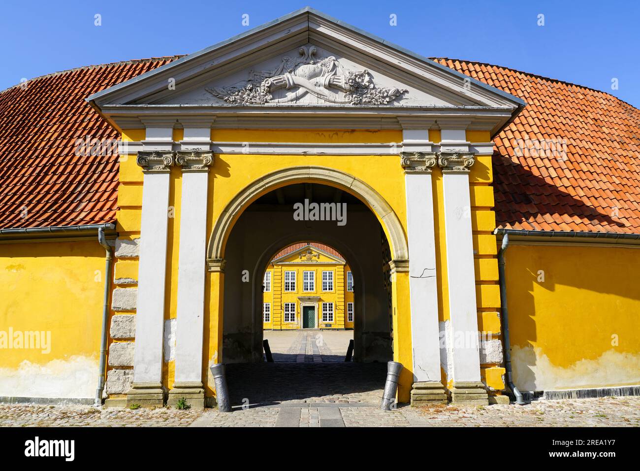Roskilde, Denmark- May 28, 2023: view through yellow arch to royal palace in Roskilde, built in 1733-36, now a museum of contemporary art Stock Photo
