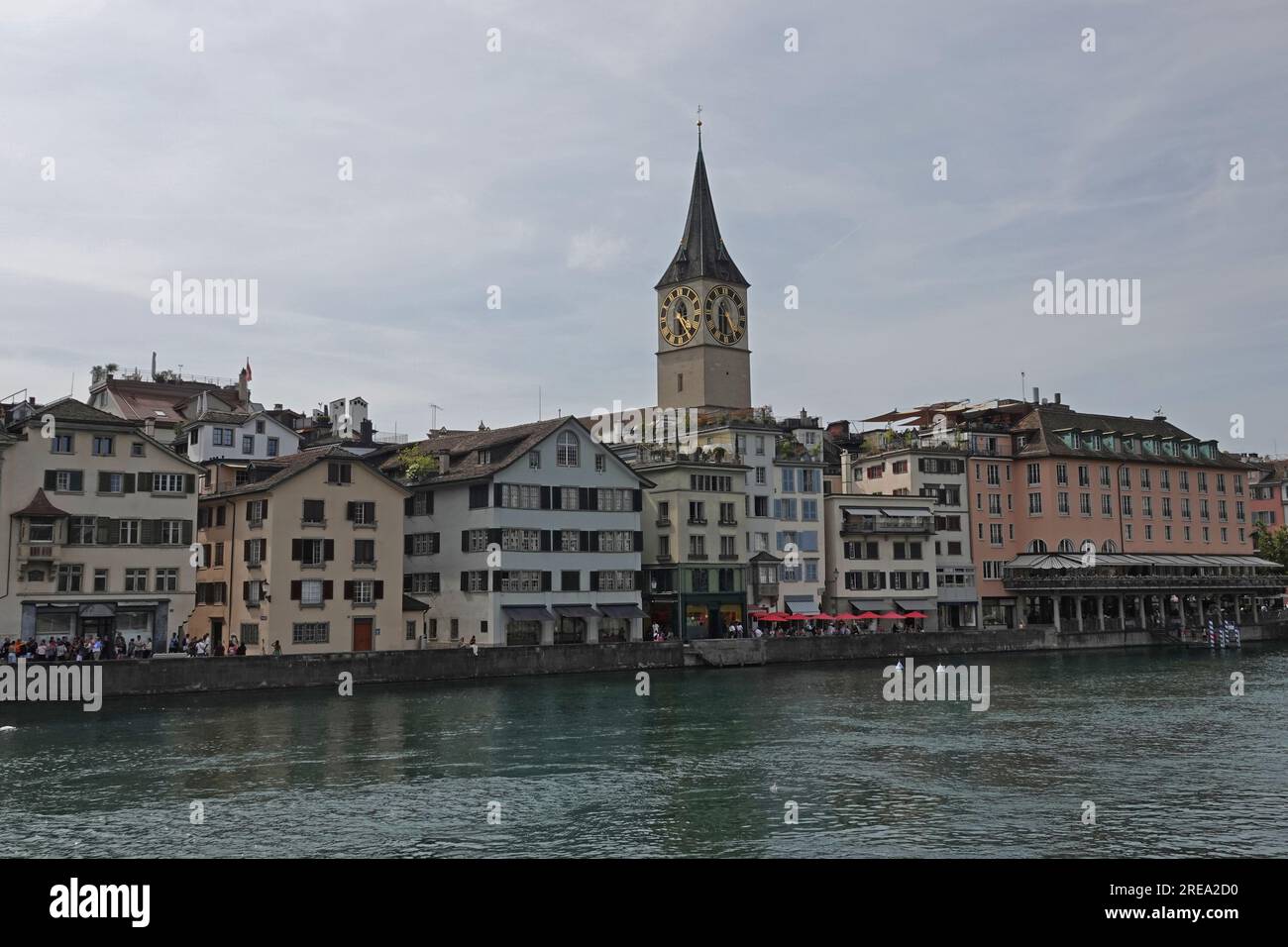 Old Town Zurich, Switzerland is shown during the day, with the Limmat River in the foreground. Stock Photo