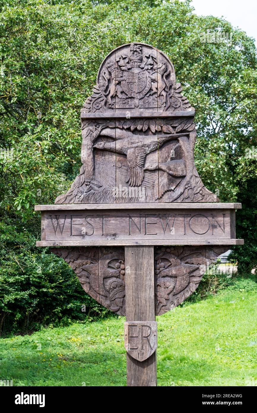 The carved wooden village sign for the village of West Newton on the Sandringham estate in Norfolk. Stock Photo
