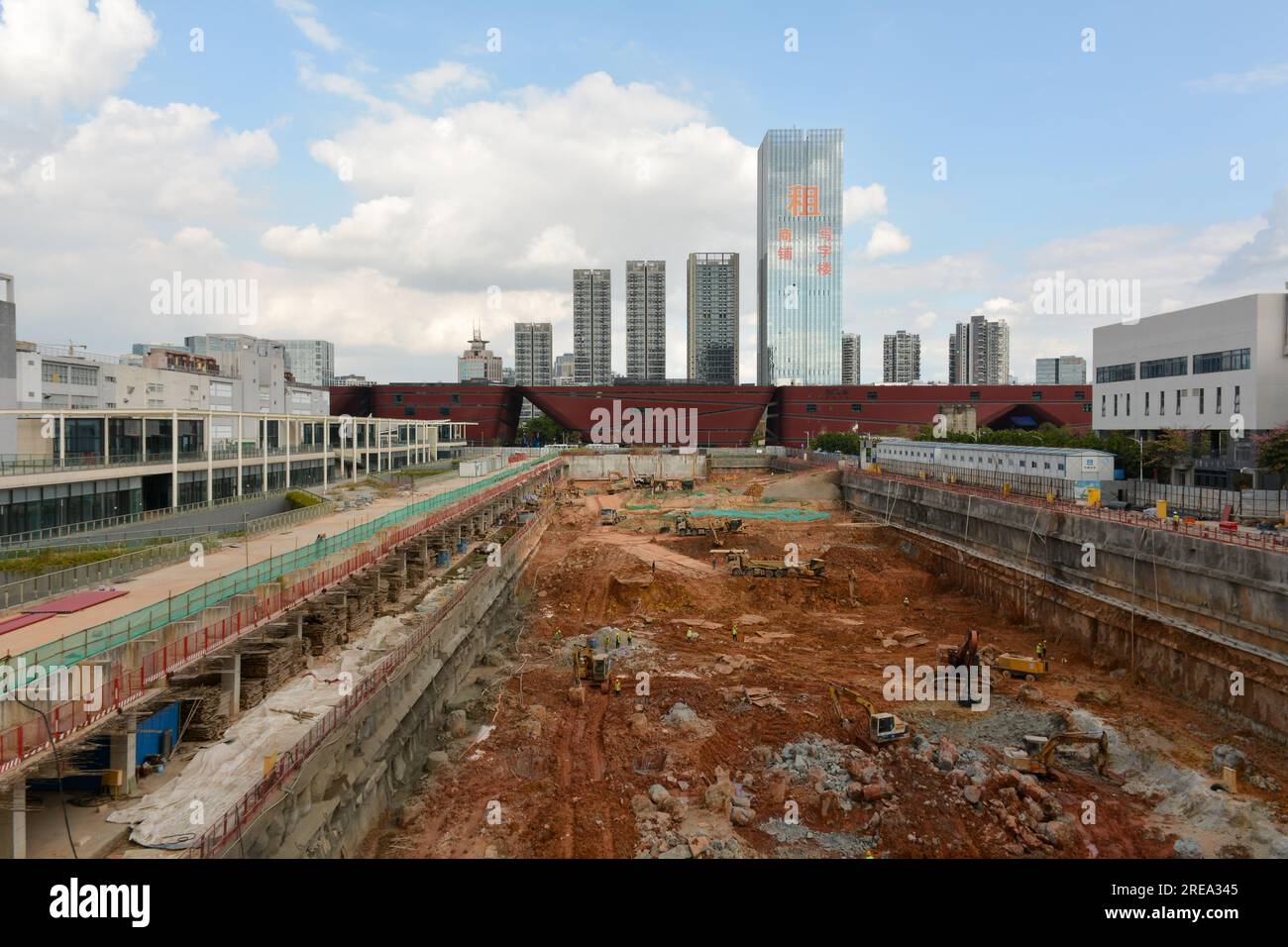 Chinese construction site in the city of Shenzhen, China. Preparing foundations for another skyscraper like the ones in the distance. December 2019 Stock Photo