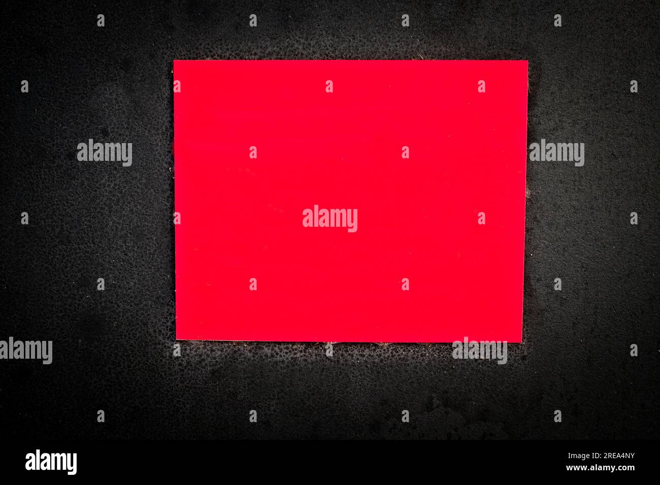 Empty red warning plate on a black background. Stock Photo