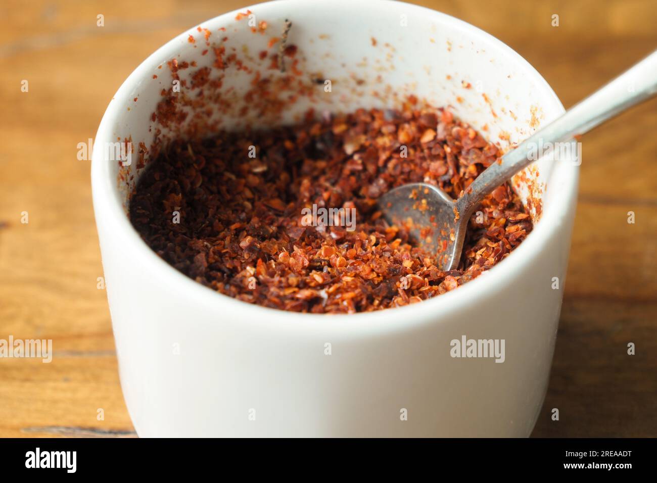 chili flakes in a bowl on table  Stock Photo