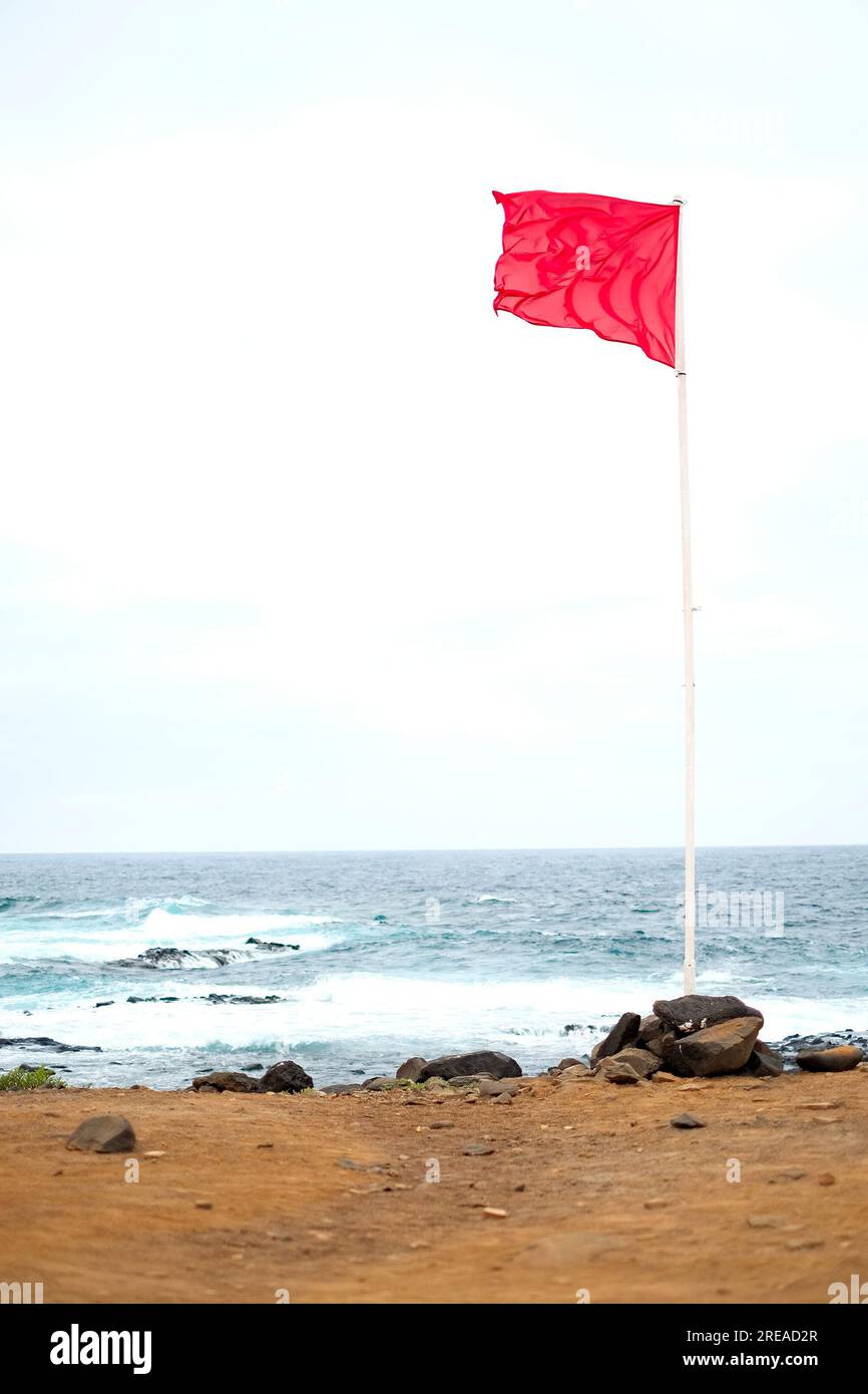 Red warning flag on the ocean shore. Stock Photo