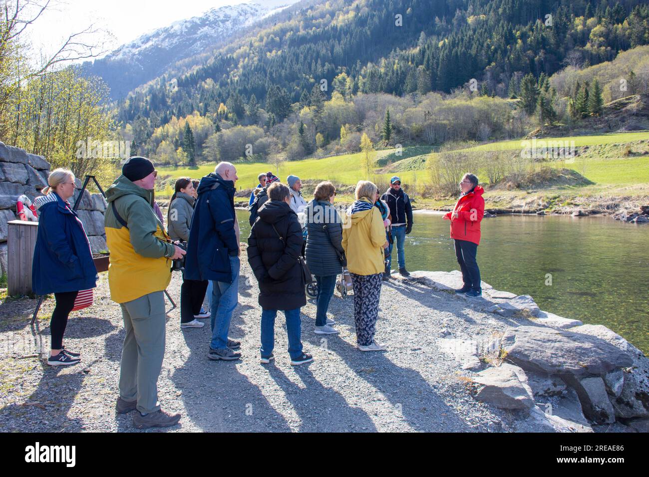 Tour guide describing early years of fly fishing on Eid River (Eidselva) to group, Nordfjordeid, Vestland County, Norway Stock Photo