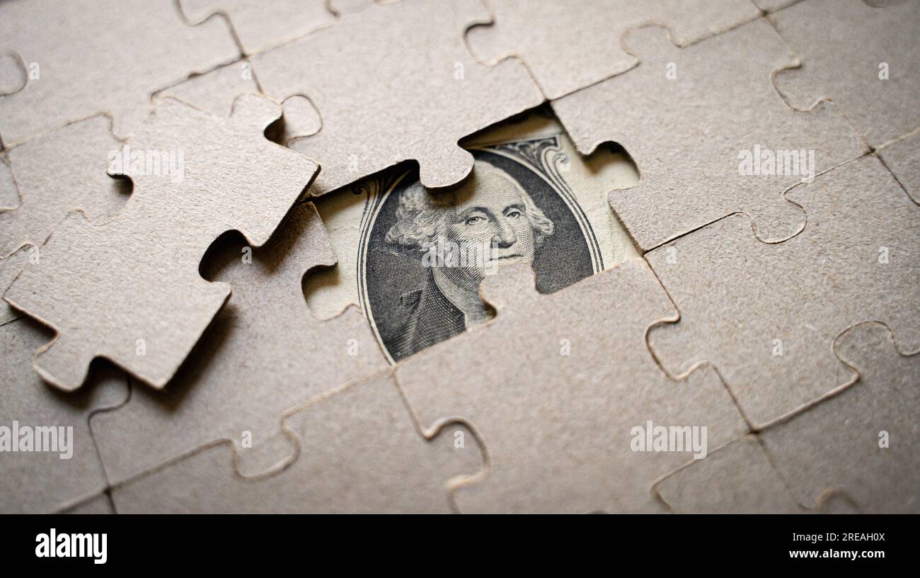 The head of George Washington on the dollar bill seen through a jigsaw puzzle Stock Photo