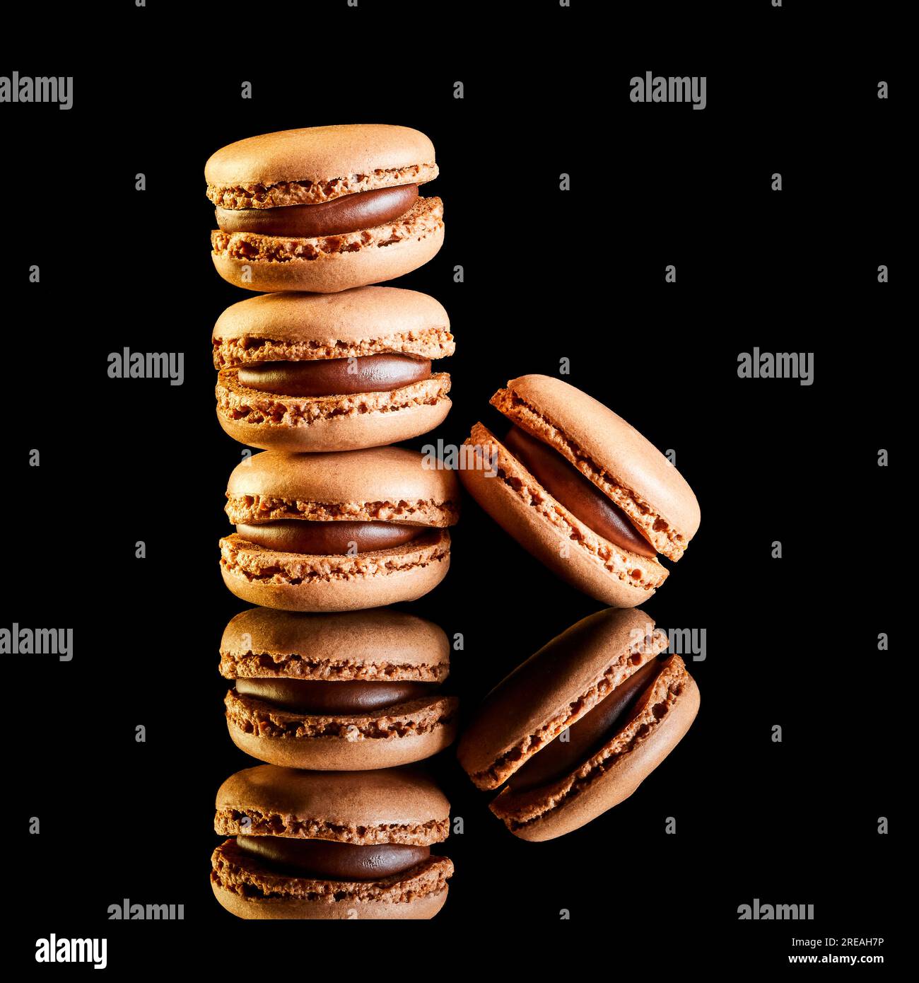 Stack of flavoured coloured macarons on a reflective surface with coffee beans Stock Photo