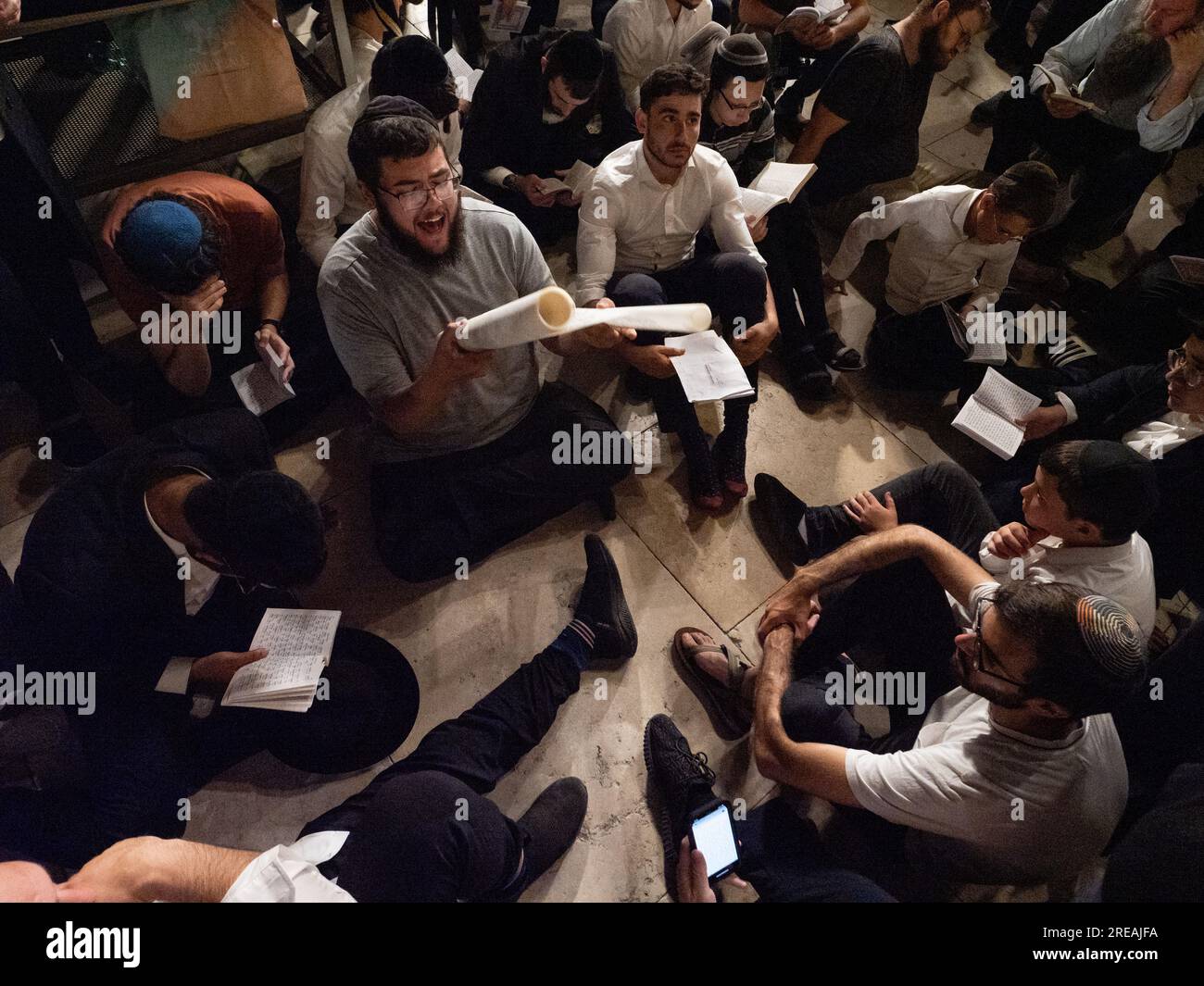 Jerusalem, Israel. 26th July, 2023. A man reading the book of Eicha (Book of Lamentations) for a group of people during Tisha B'Av memorial day in the Western Wall in Jerusalem. © Valentin Sama-Rojo/Alamy Live News. Stock Photo