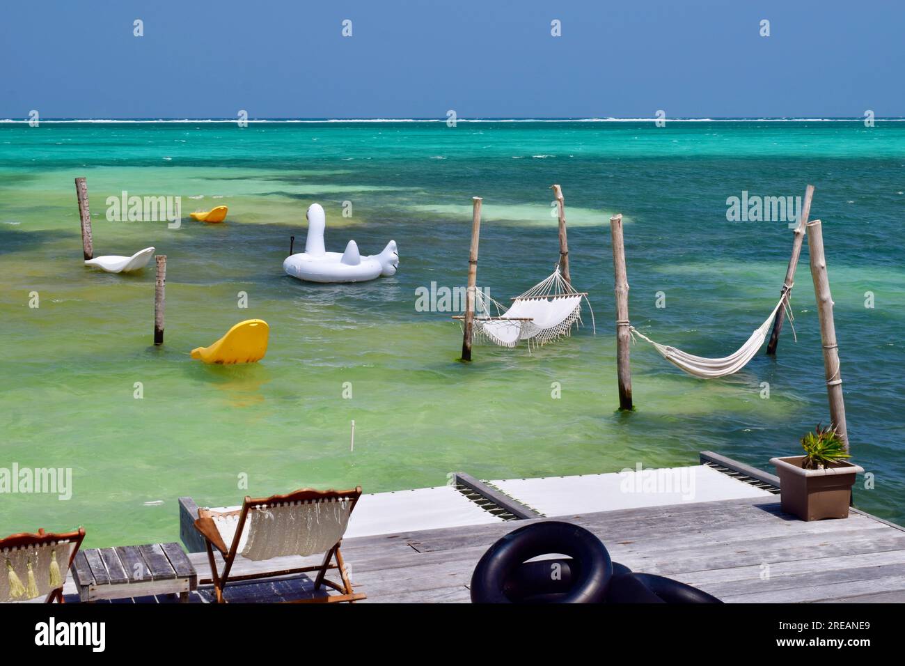 Hammocks and pool floats over the Caribbean Sea, within the Belize
