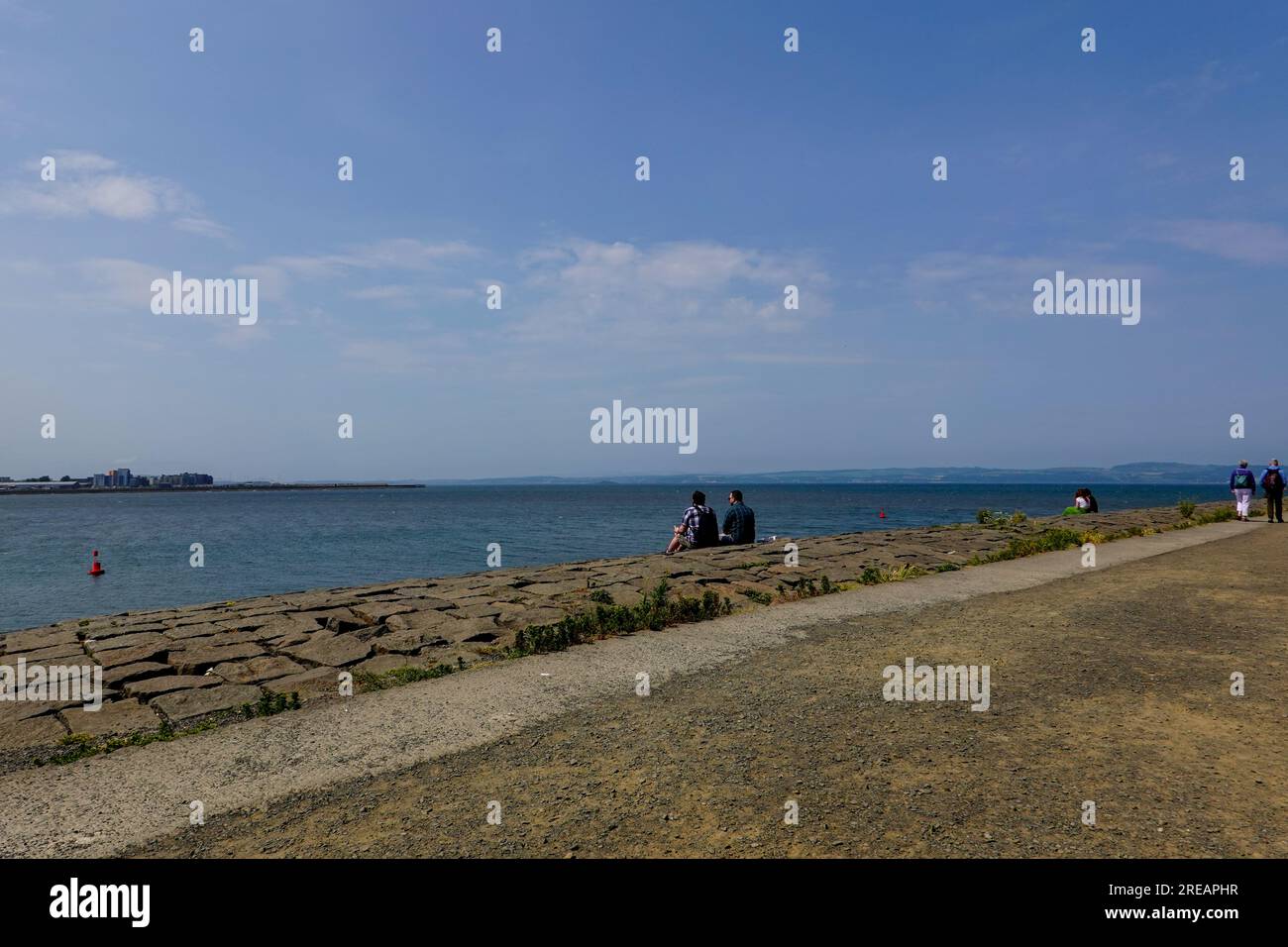 People down by the Newhaven waterfront overlooking the Firth of Forth, from Edinburgh, Scotland, UK. Stock Photo