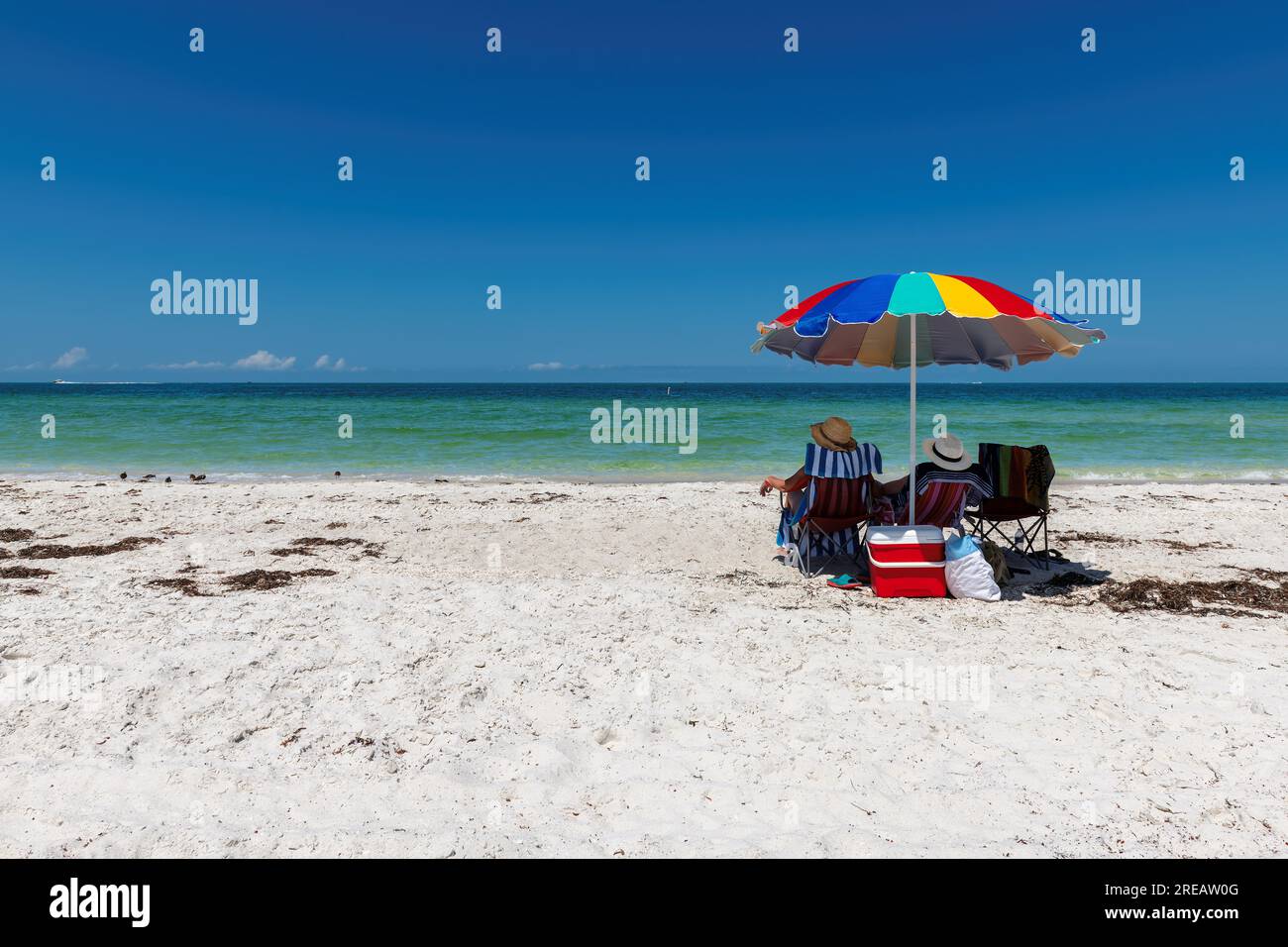 Sunny beach and tropical sea with colorful umbrella Stock Photo