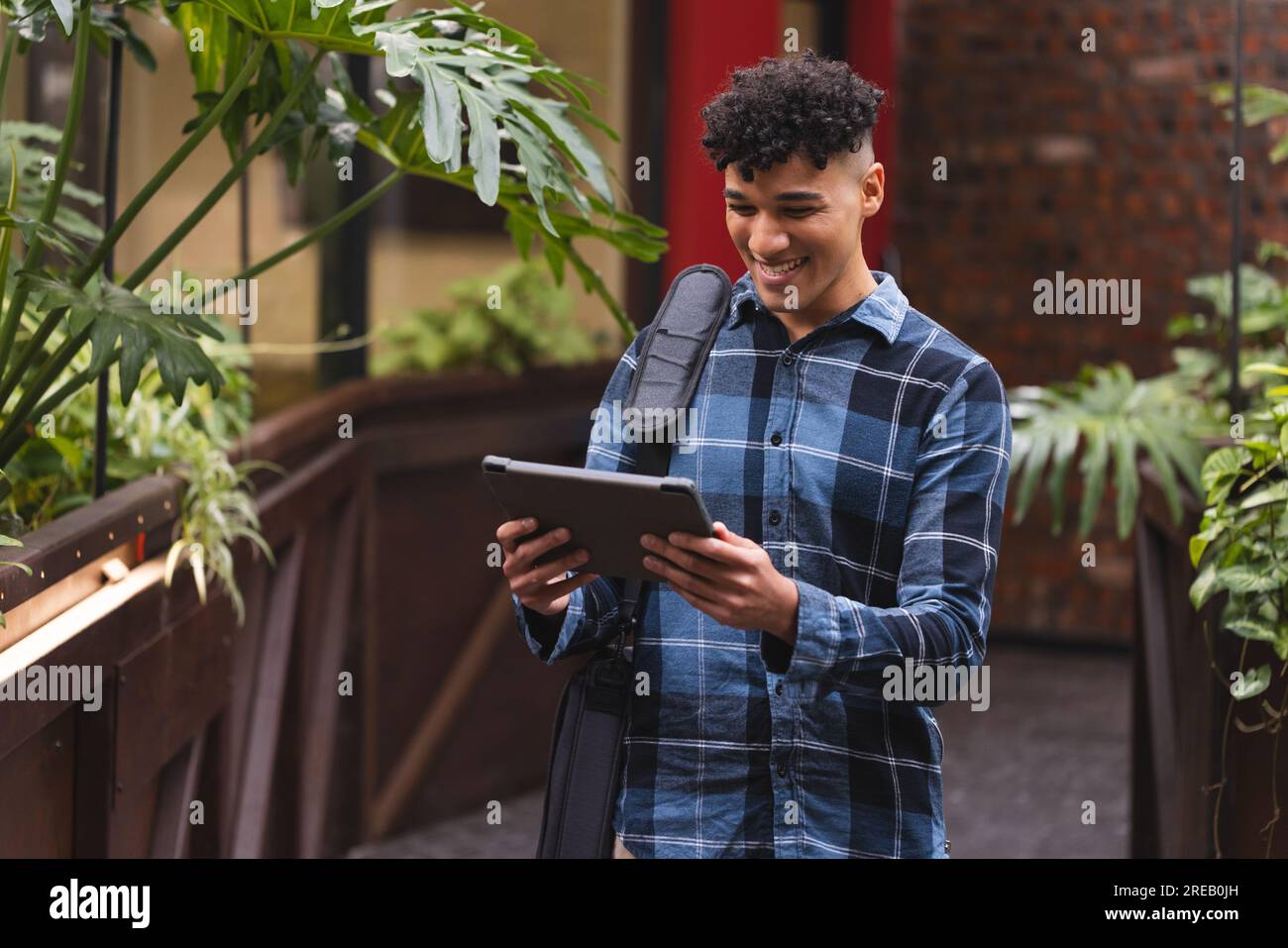 Biracial man smiling while using a digital tablet at office Stock Photo