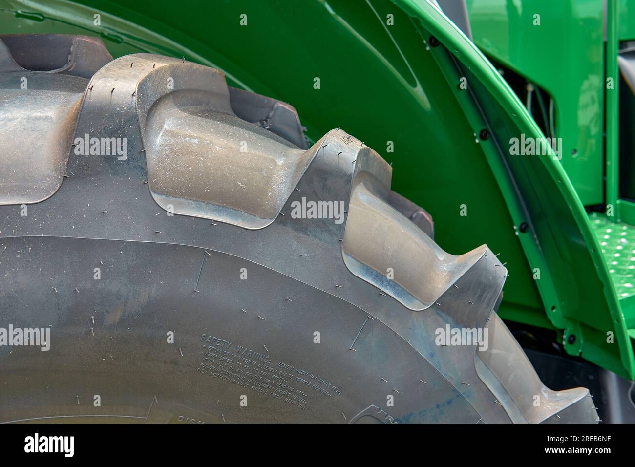 Closeup of a tractor tire tread against a green fender at the Delaware State Fair, Harrington, Delaware USA. Stock Photo