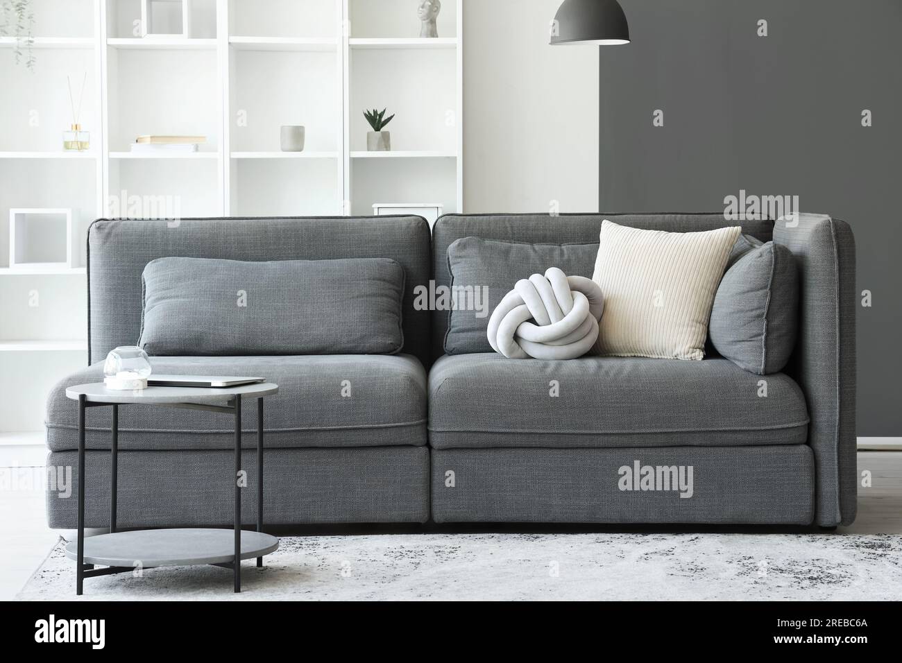 Interior of light living room with cozy grey sofa and coffee table ...