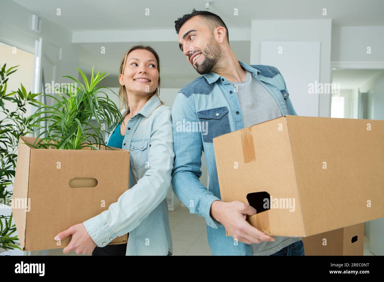 couple moving into a new house carrying cardboard boxes Stock Photo - Alamy