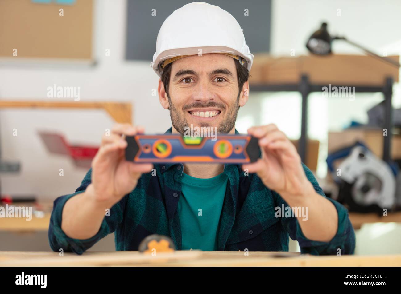 male engineer in workshop showing his spirit level Stock Photo
