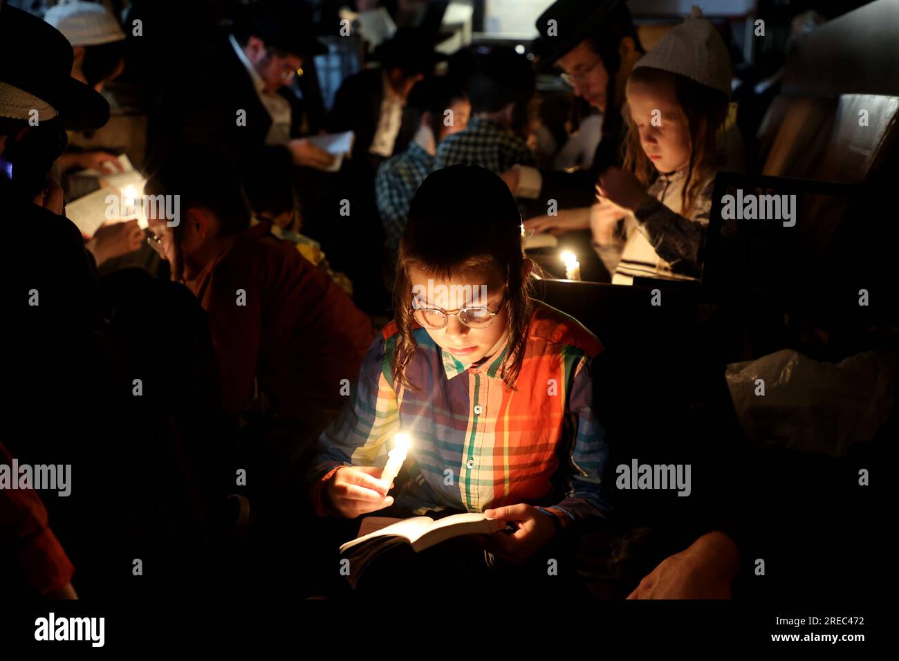 Jerusalem. 26th July, 2023. Ultra-Orthodox Jews light candles to read the Book of Lamentations during the annual fasting and memorial day of Tisha B'Av in the Ultra-Orthodox neighborhood of Mea Shearim in Jerusalem on July 26, 2023. Credit: Gil Cohen Magen/Xinhua/Alamy Live News Stock Photo