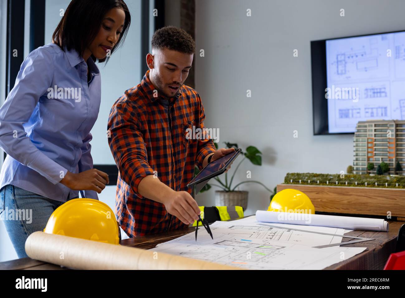 Diverse male and female architects discussing and working on a plan at office Stock Photo