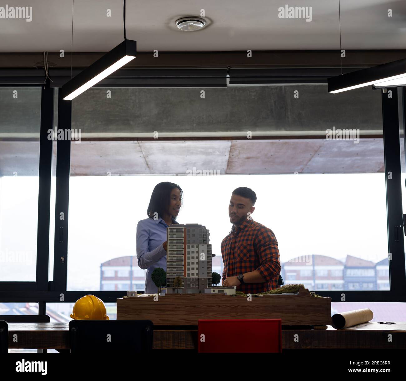 Diverse male and female architects discussing and working on a building model at office Stock Photo