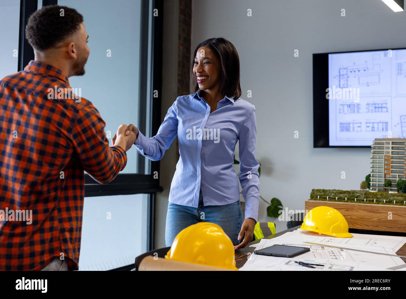 Happy diverse male and female architects shaking hands at office Stock Photo