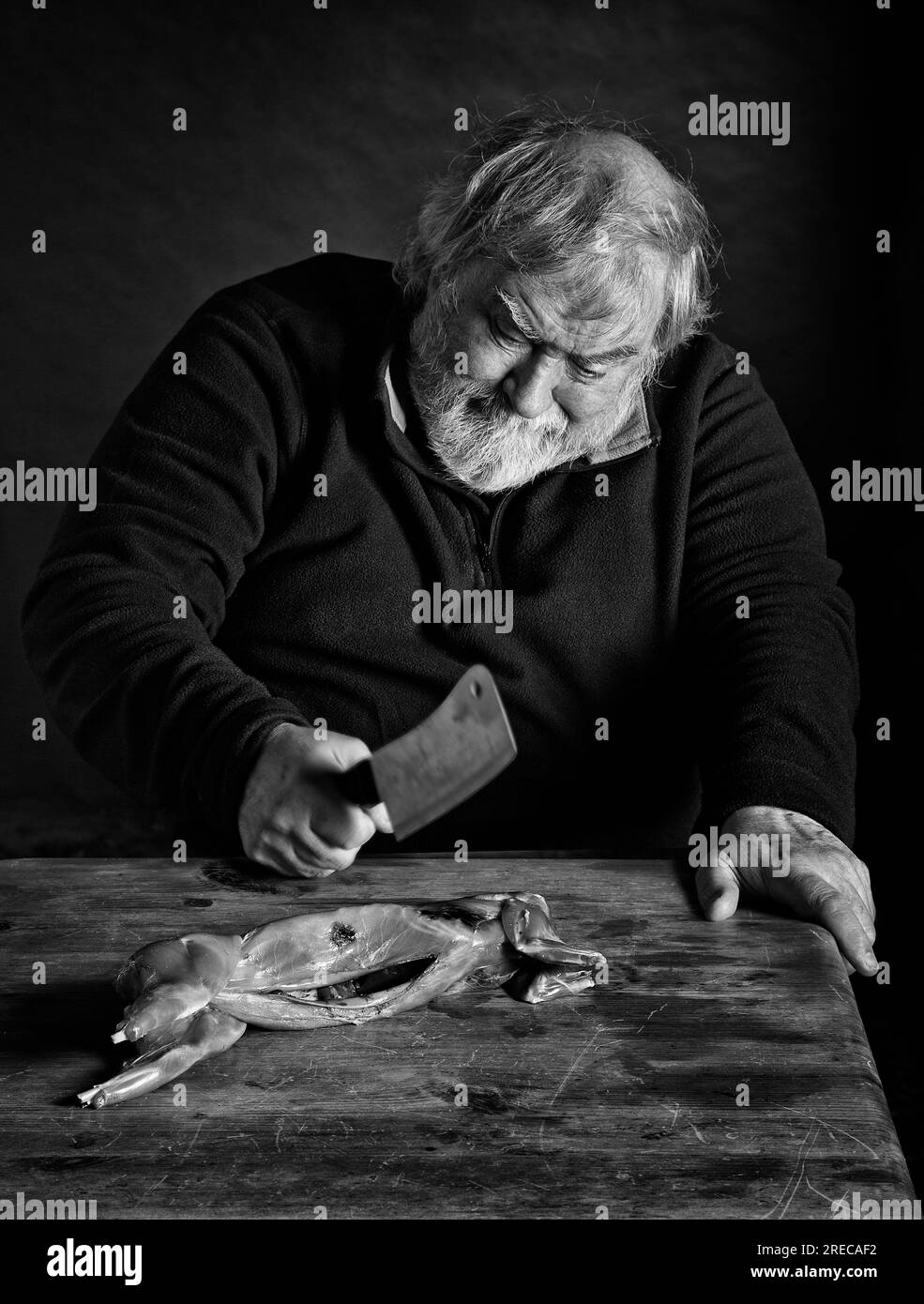 Man chopping up wild rabbit meat Stock Photo