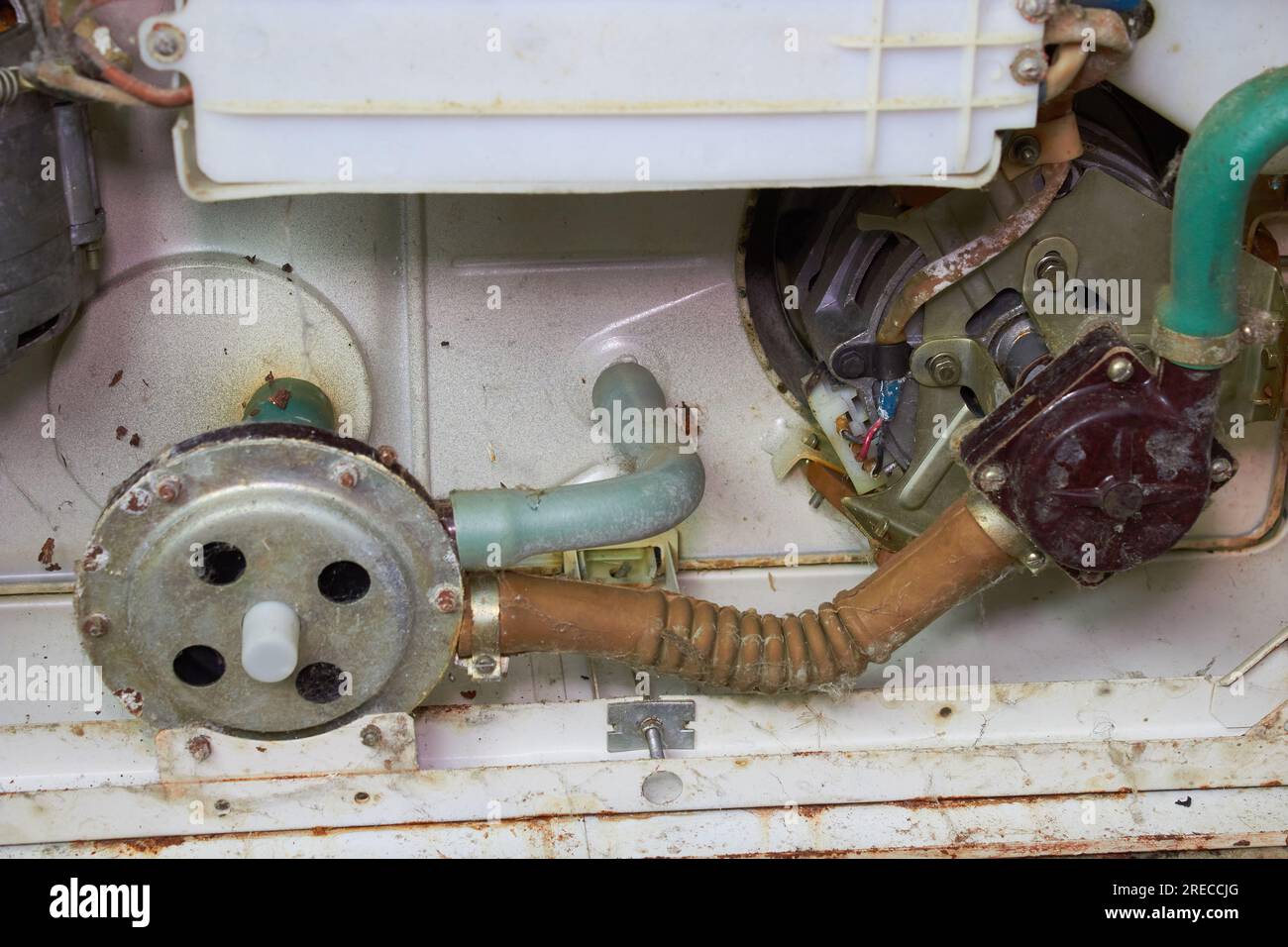 the old washing machine is broken, connecting the hoses to the motor circulating water Stock Photo