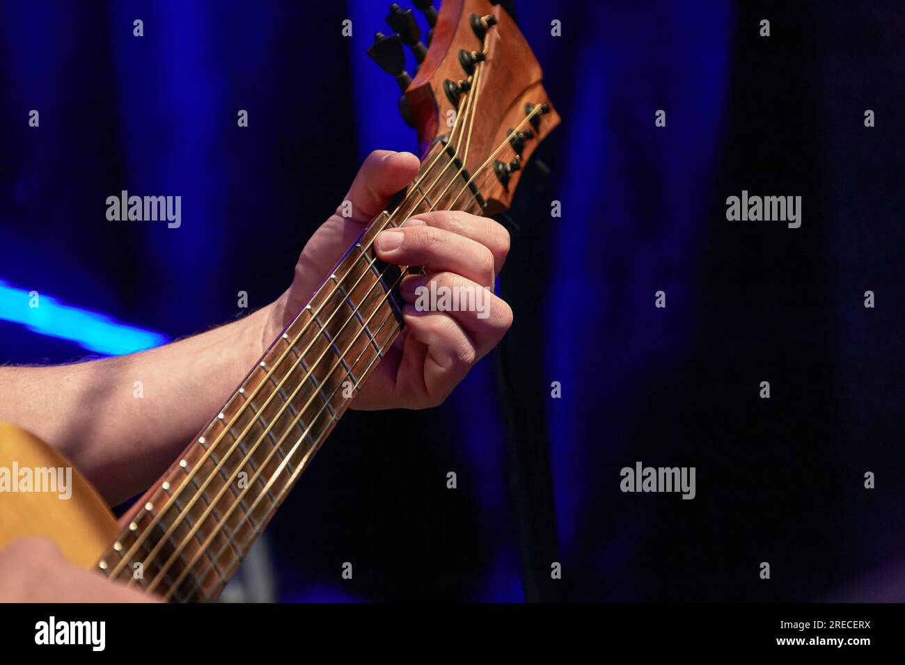 Image of fingers taking a chord on the fretboard of an acoustic guitar Stock Photo