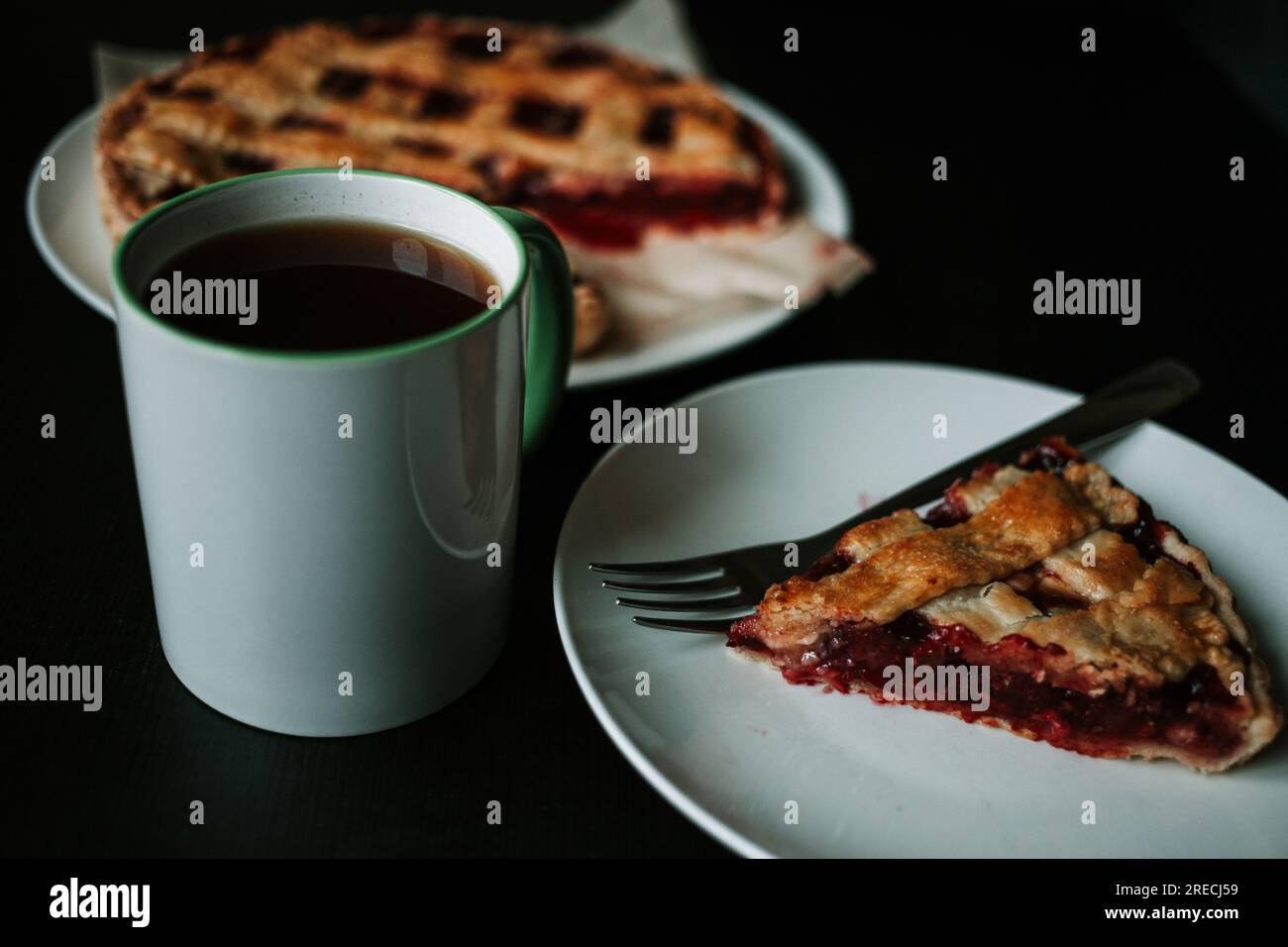 Cherry pie with a cup of regular coffee on black table Stock Photo