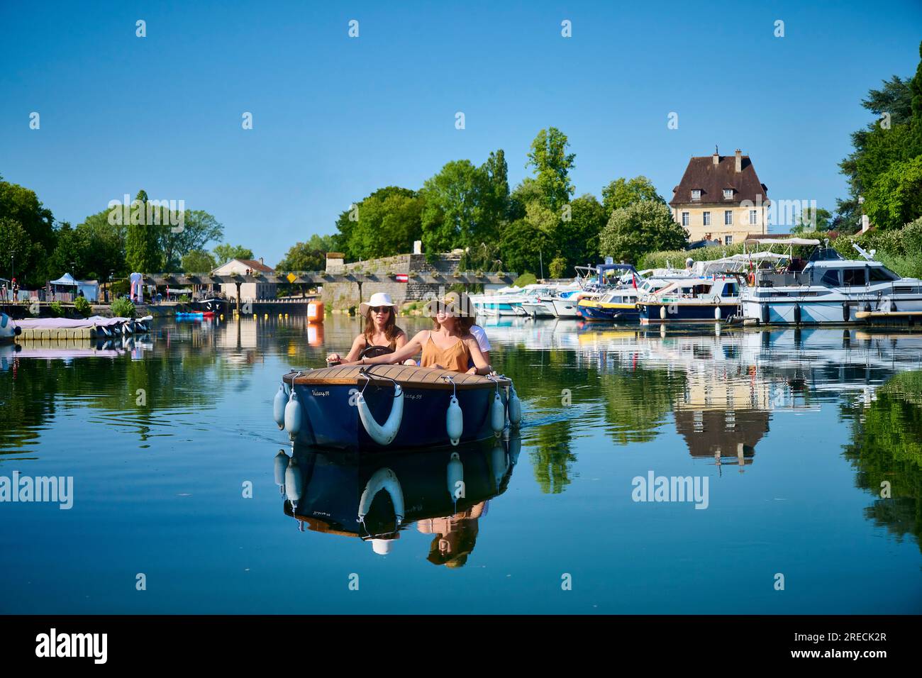 Electric boat, group of friends on a boat trip on the Canal Charles Quint and the river Doubs in Dole (north eastern France). Three young women on a b Stock Photo