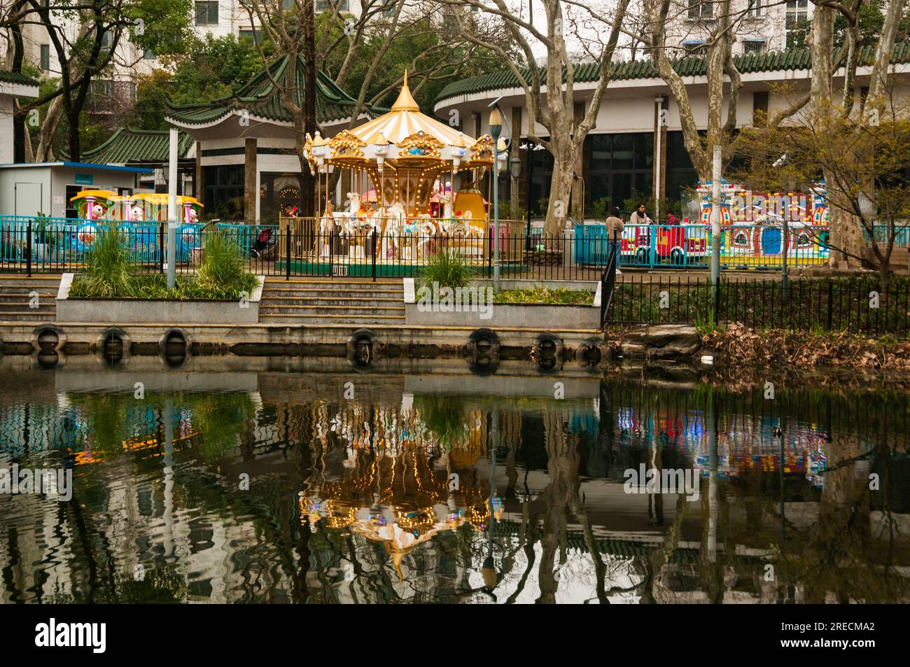 The small amusement park for children in Tianshan Park reflected in the lake Changning District