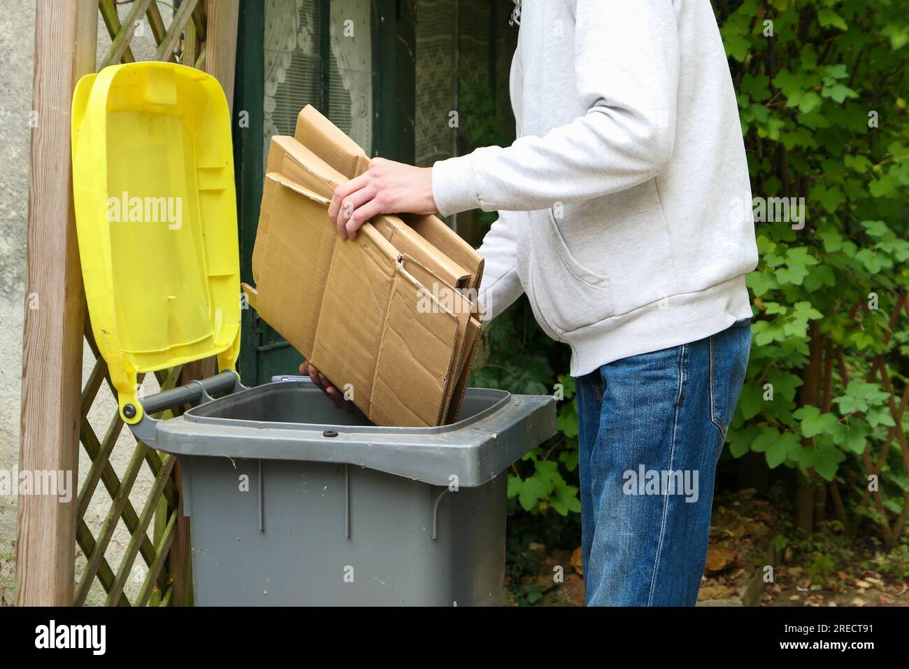 A person who sorts packaging waste. Man putting packing boxes into