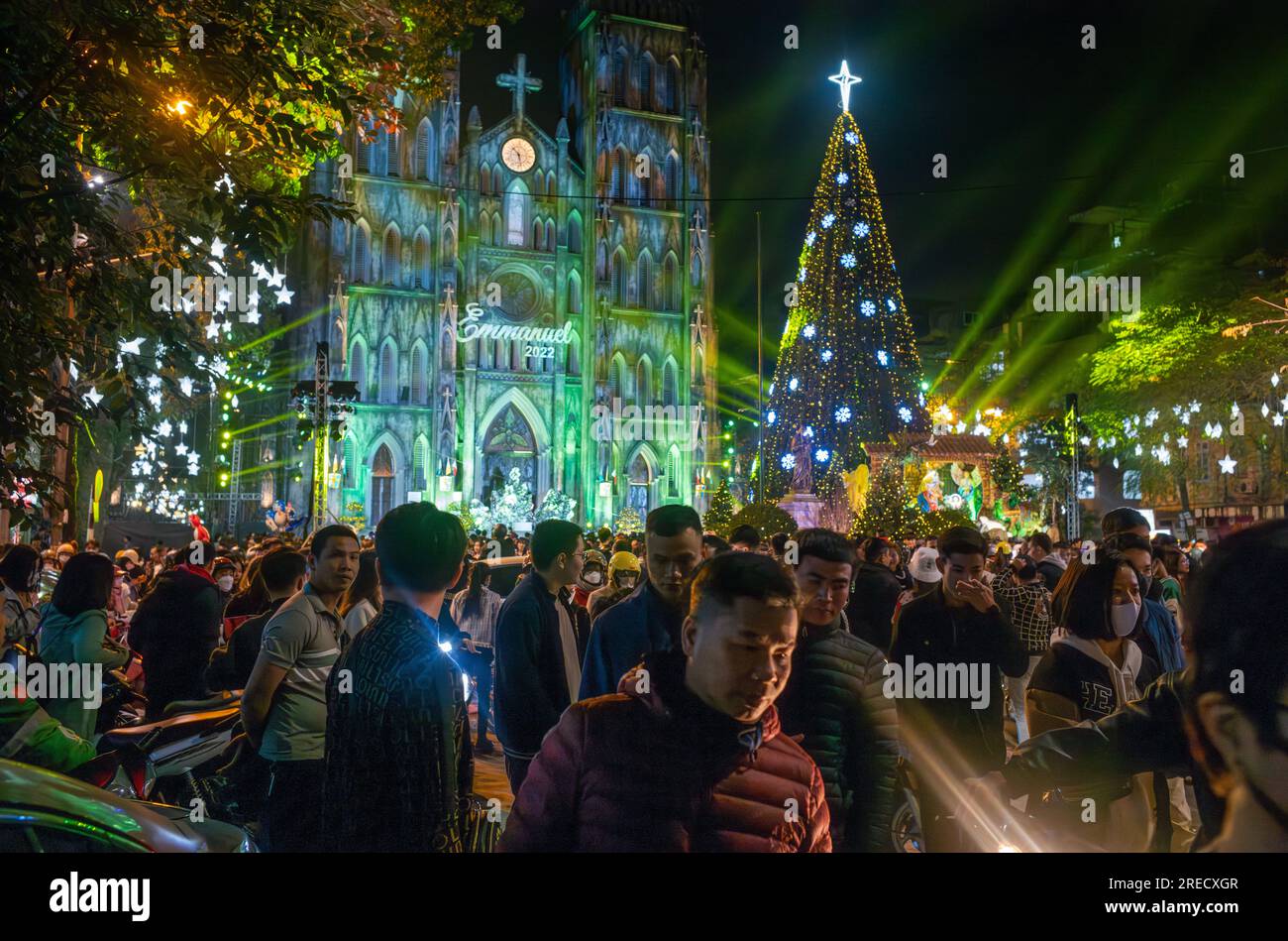 Crowds of Vietnamese people gather next to the dramatically illuminated St Joseph's Cathedral and its Christmas Tree at Christmas time in Hanoi, Vietn Stock Photo