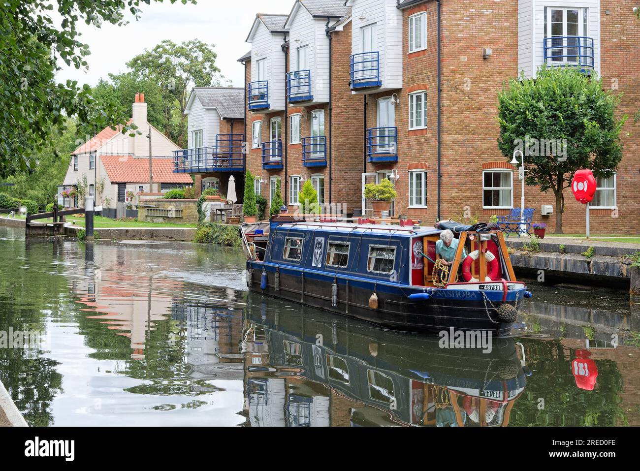 A small narrow boat exiting Thames Lock on the River Wey navigation