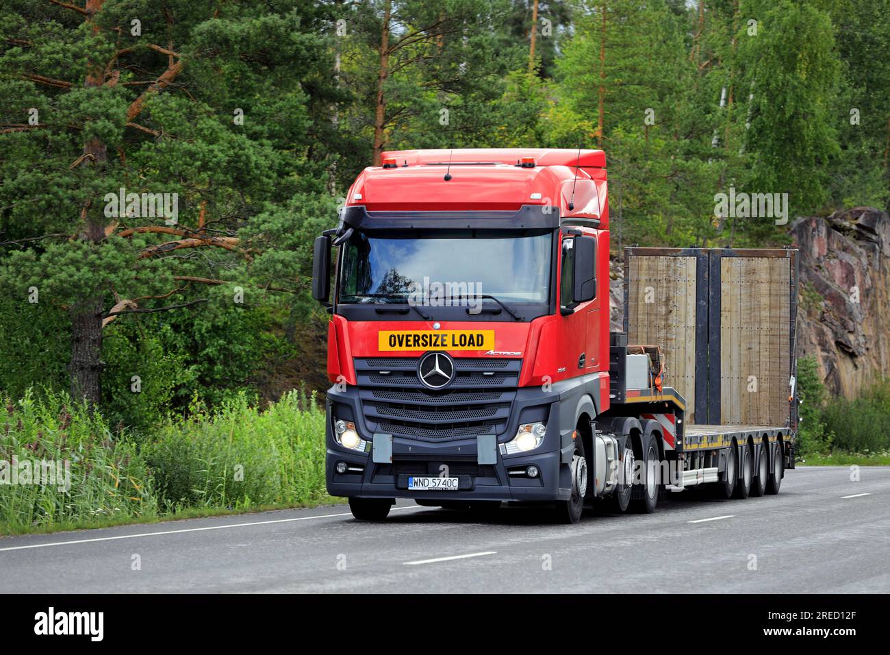 Red Mercedes-Benz Actros 2545 truck gooseneck trailer ready for oversize load transport. Salo, Finland. July 20, 2023. Stock Photo