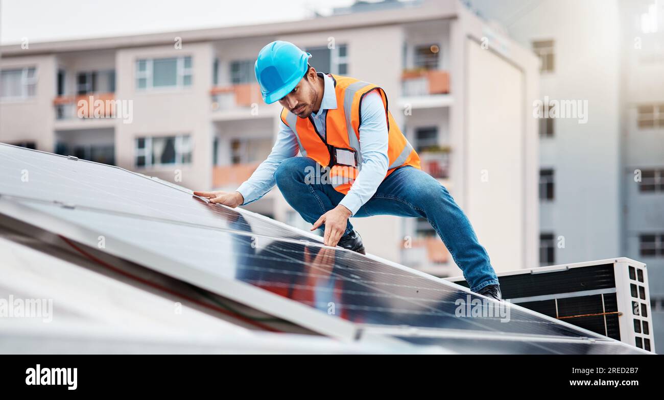 Technician man, construction and solar panel on roof for maintenance, sustainability or inspection in city. Engineer, check and photovoltaic system Stock Photo