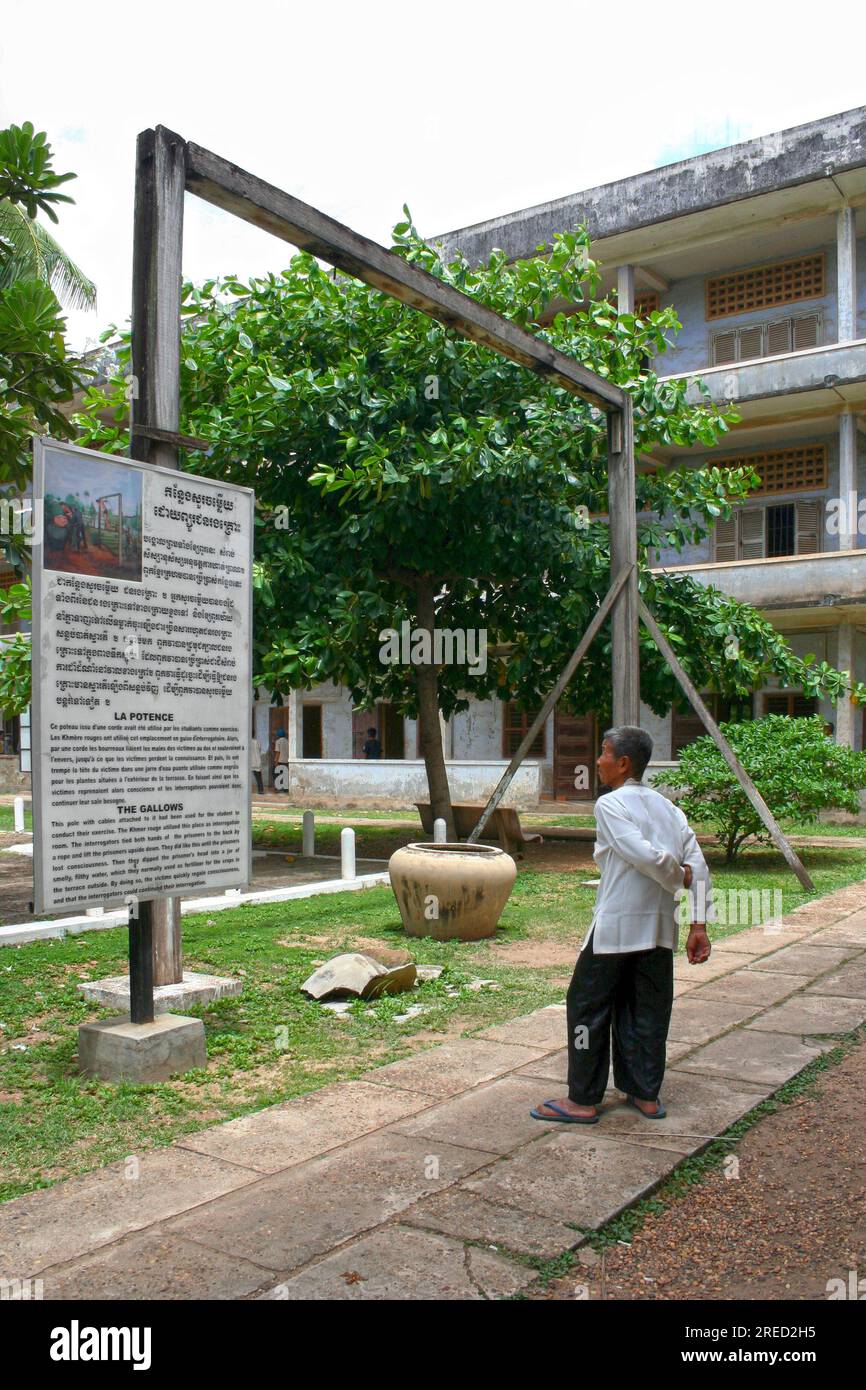 Phnom Penh, Cambodia - July, 16 2006: Old Cambodian man reading a placard about the “gallows” in S21, the former prison during the Khmer Rouge regime. Stock Photo