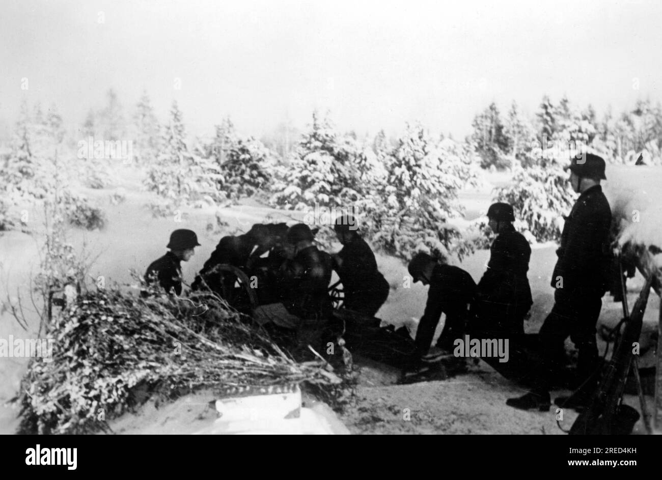 Wehrmacht soldiers at an infantry gun in a wooded area near Lutschki in