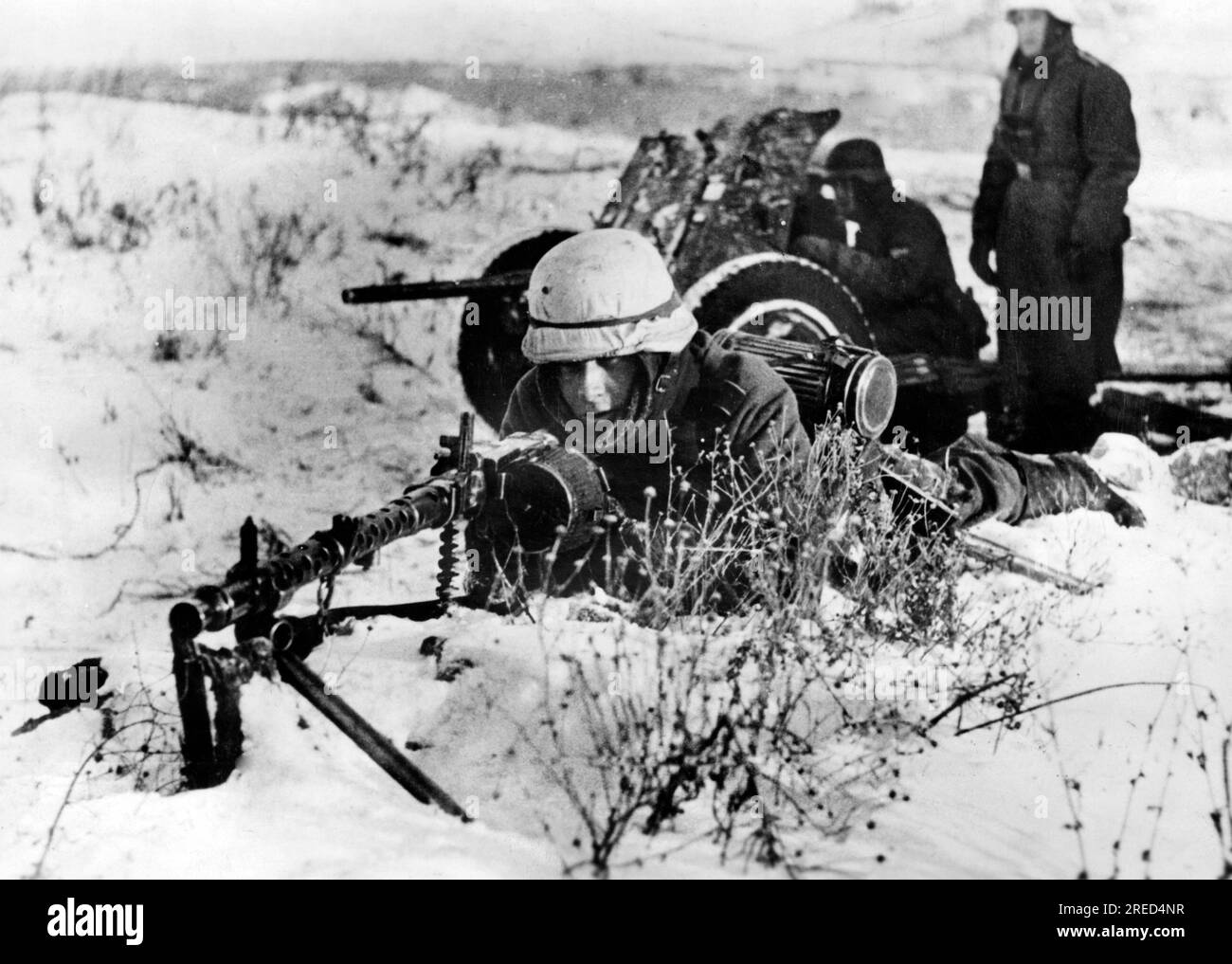 A German machine gunner on the Eastern Front. In the background a 3.7cm Pak 36. Photo: Koll [automated translation] Stock Photo