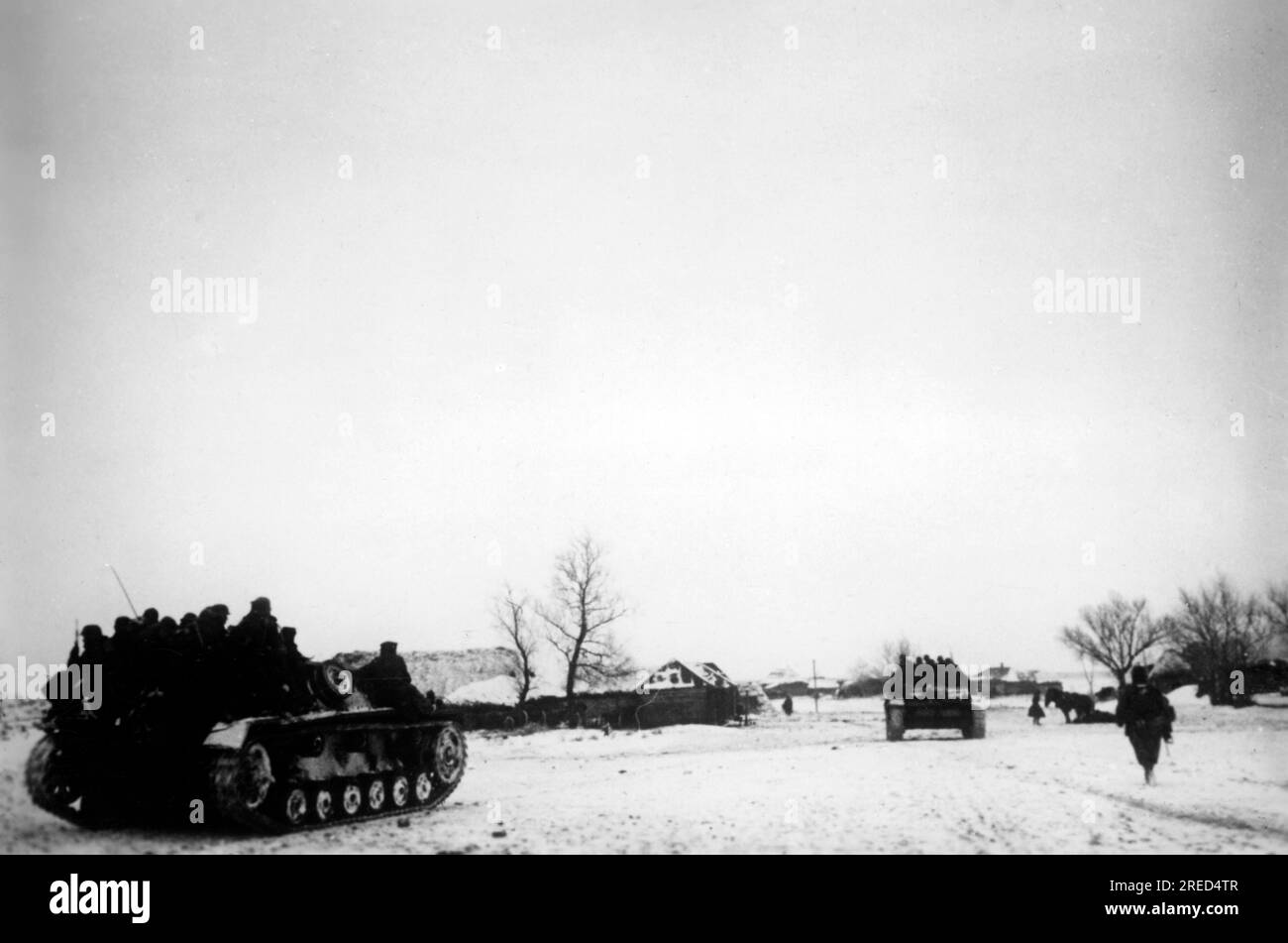 German Panzer III with mounted infantry roll into a village in the central section of the Eastern Front. Photo: Eckart [automated translation] Stock Photo
