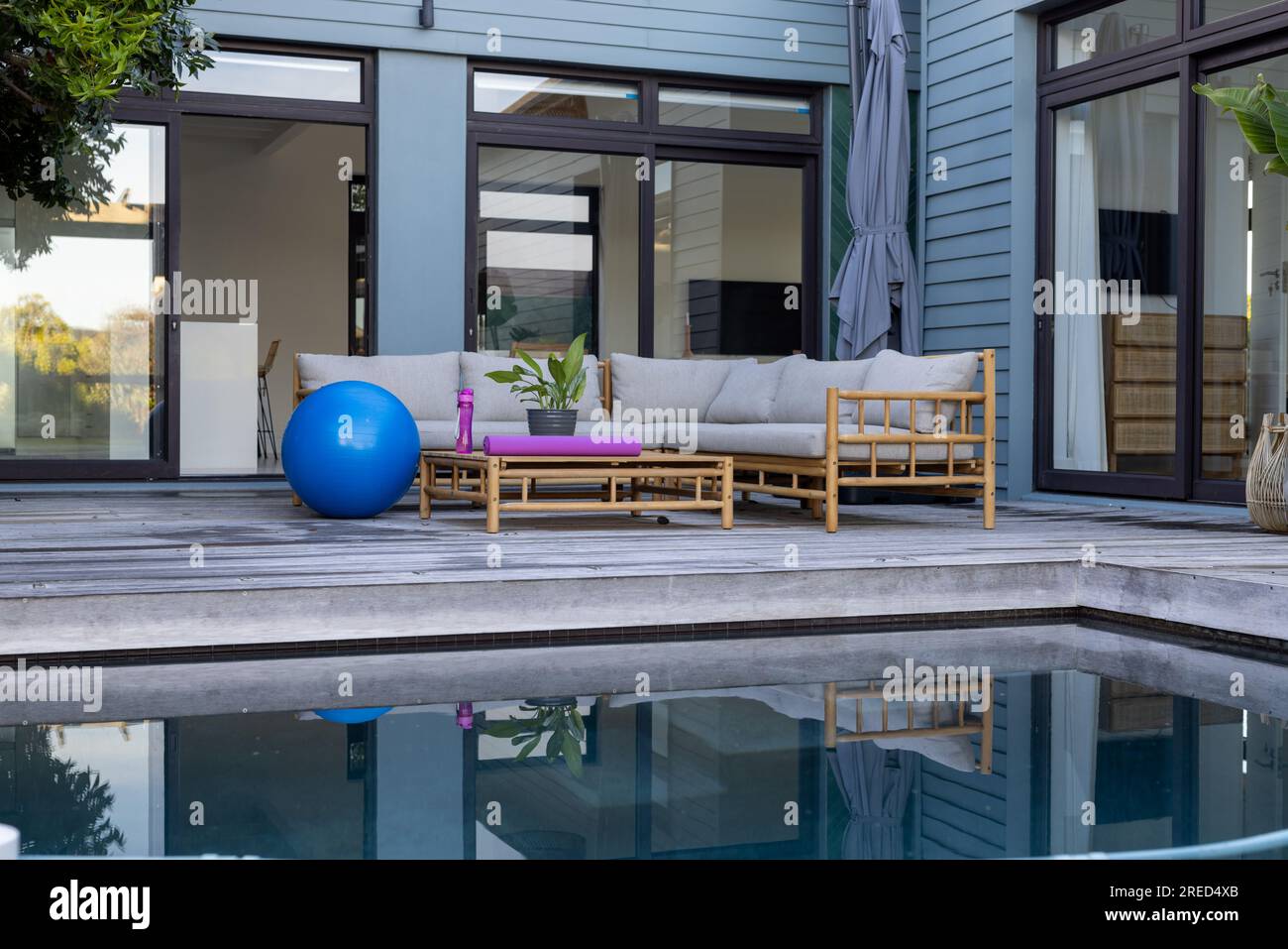 General view of terrace with swimming pool, sofa and fitness equipment Stock Photo
