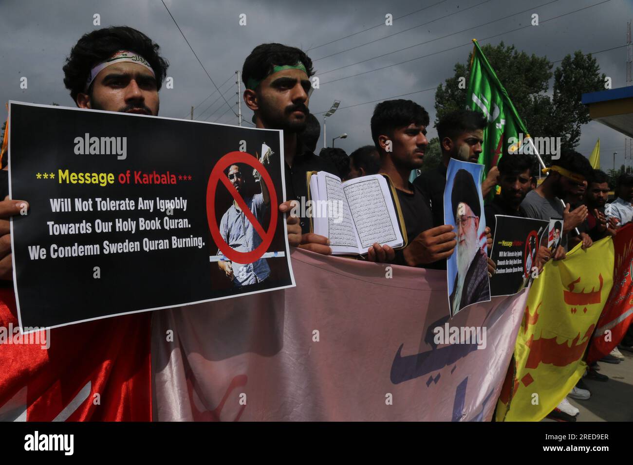 Kashmiri Shiite mourners hold placards and the Quran as they take part ...
