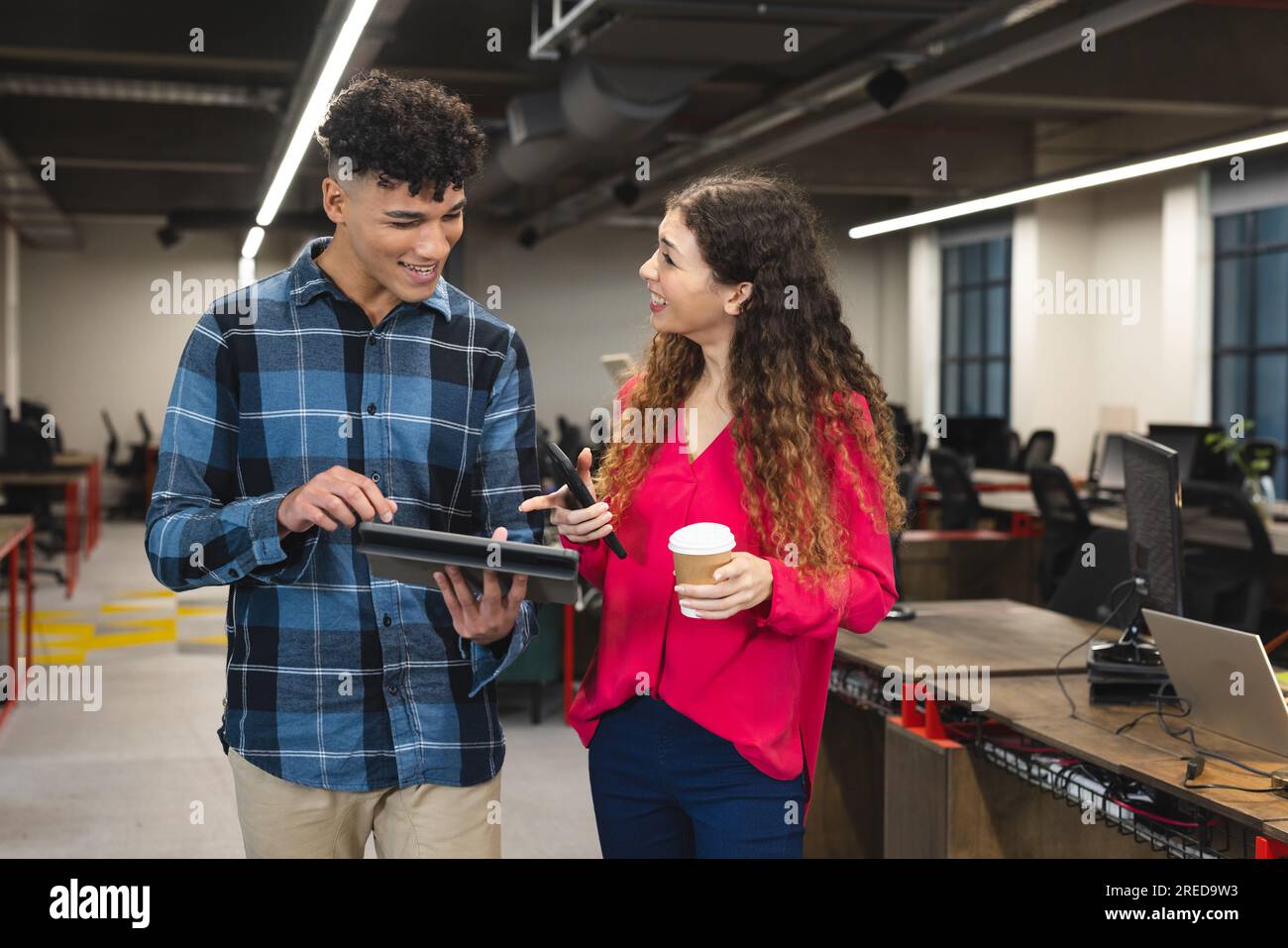Busy diverse male and female colleagues using tablet and talking ...