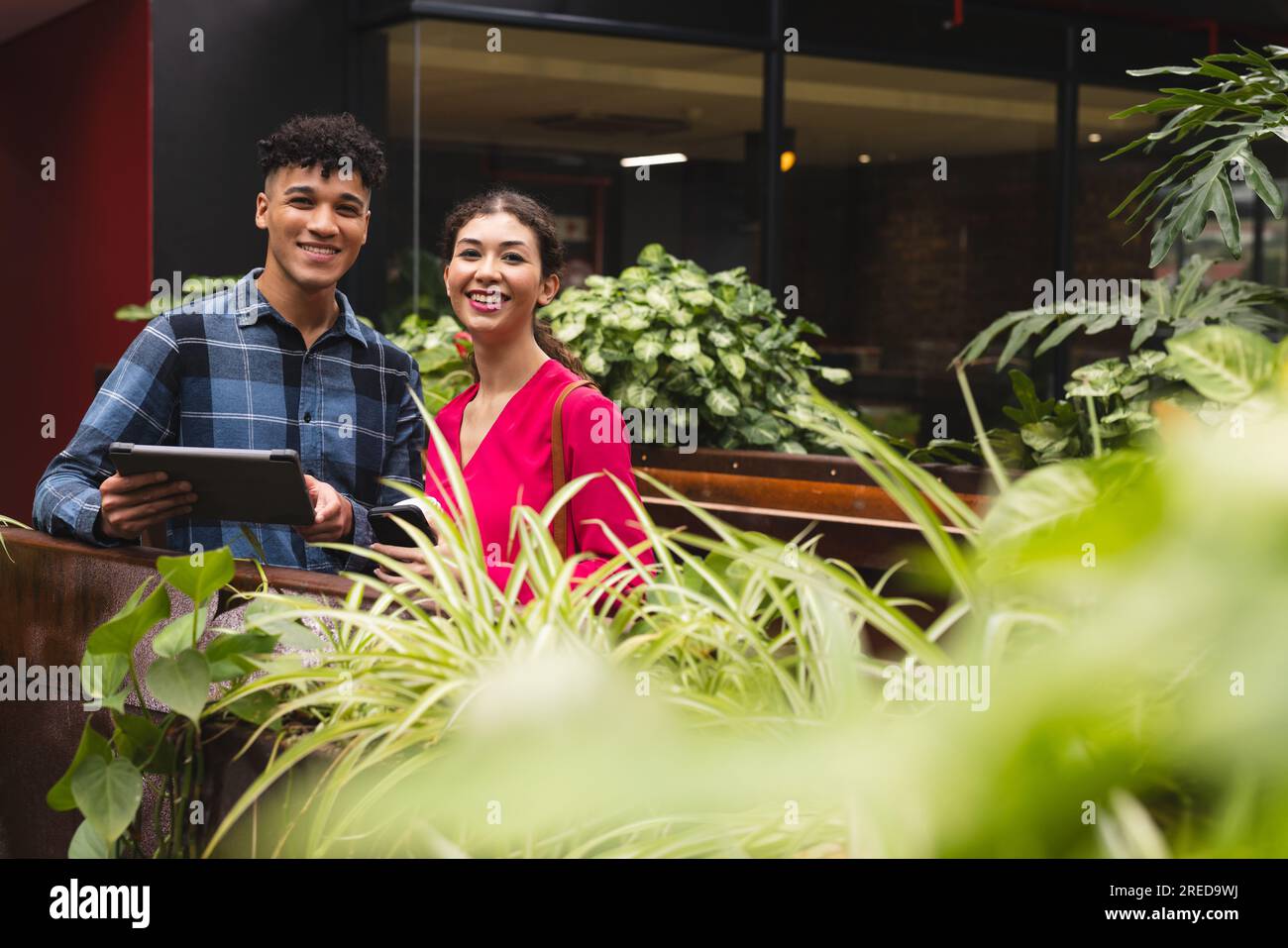 Portrait of diverse male and female colleagues with tablet smiling in ...