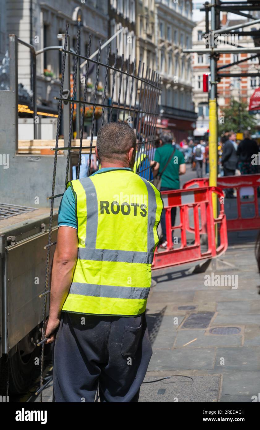 Construction workers unloading reinforcing steel mesh from delivery