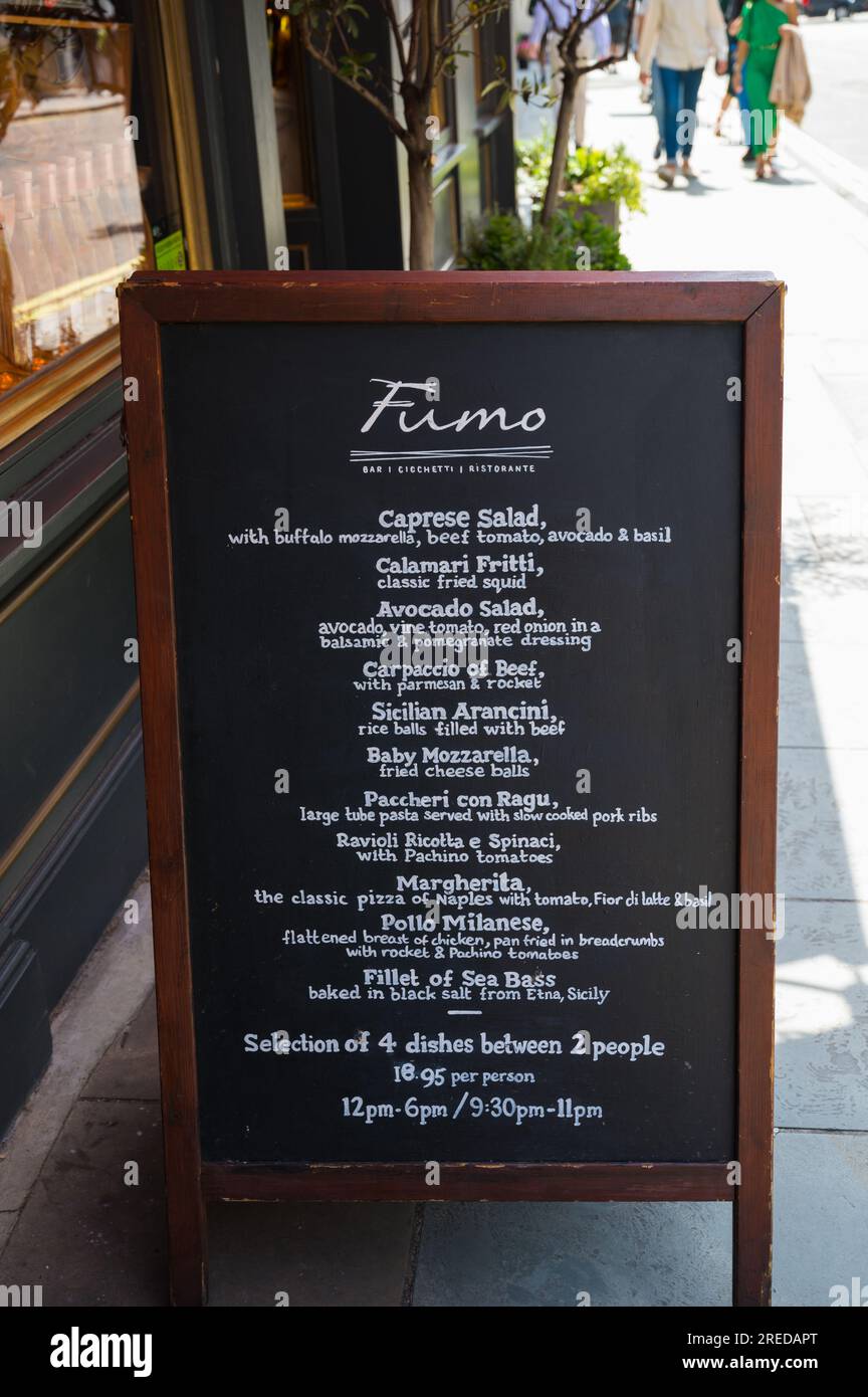 Menu written on blackboard standing on pavement outside Fumo Italian restaurant on St Martins Lane, Covent Garden, London, England, UK Stock Photo