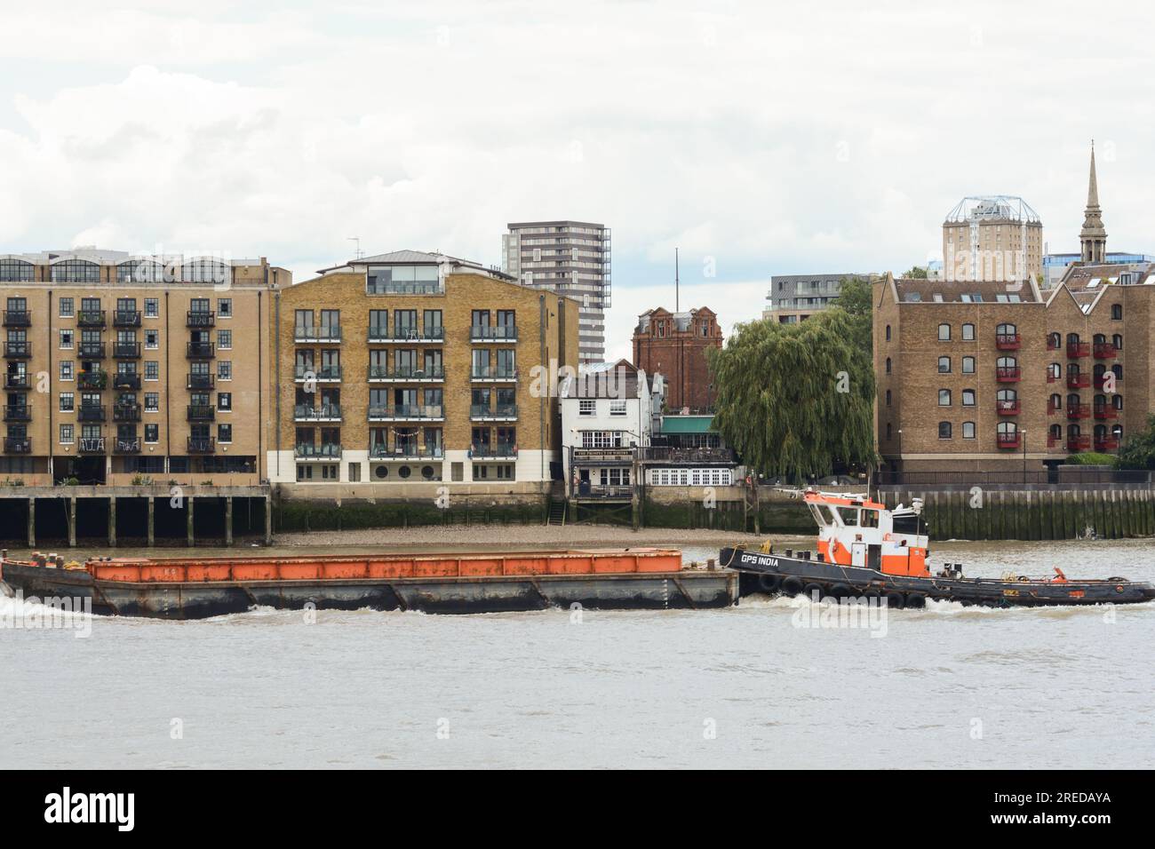 The GPS tug India passing the Prospect of Whitby - an historic public house on the banks of the River Thames at Wapping, London, E1, England, U.K. Stock Photo