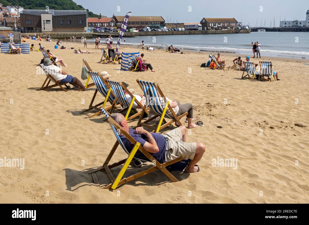 People tourists visitors relaxing on deckchairs South Bay beach in summer Scarborough North Yorkshire England UK United Kingdom GB Great Britain Stock Photo
