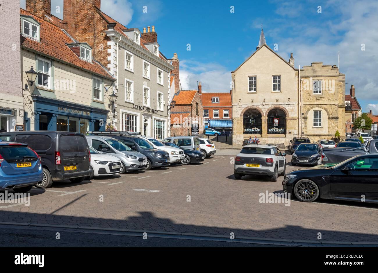 The old Town Hall and cars parked on the street in Market Place in summer Malton North Yorkshire England UK United Kingdom GB Great Britain Stock Photo