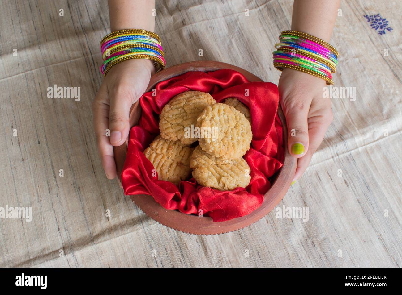 Thekua , an Indian sweet dish or a snacks in earthen pot holding by woman hand. Popular in bihar jharkhand. Prashad in chhath parv or puja or festival Stock Photo