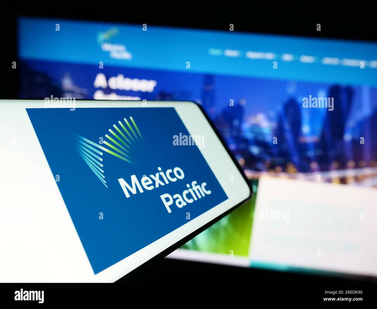 Mobile phone with logo of company Mexico Pacific Ltd. LLC on screen in front of business website. Focus on center-left of phone display. Stock Photo